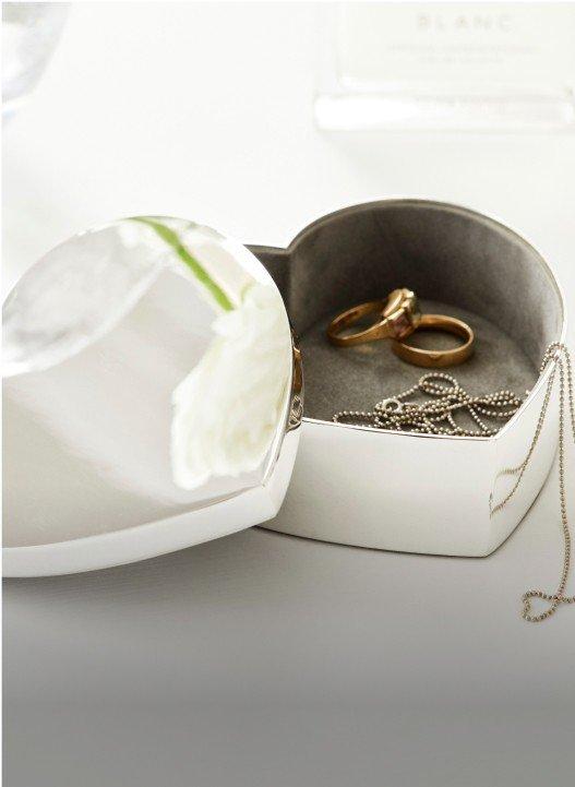 a heart shaped jewelry box with two rings inside