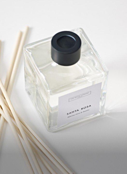 a bottle of santa rosa perfume with sticks of incense