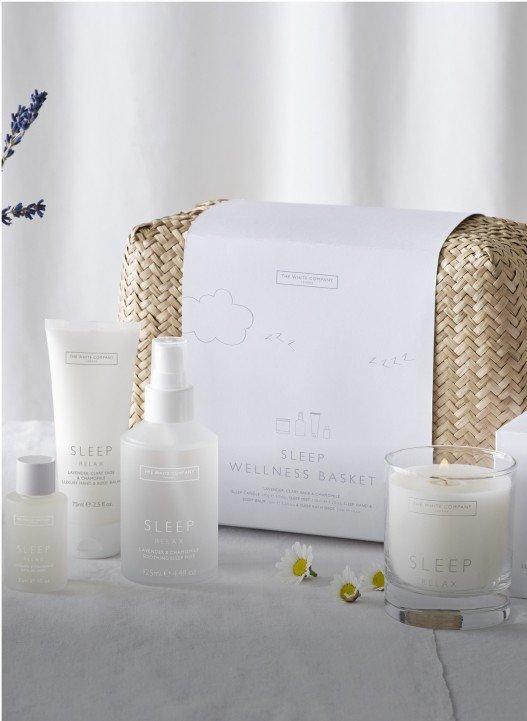 a white basket with a candle, a candle holder, and a candle