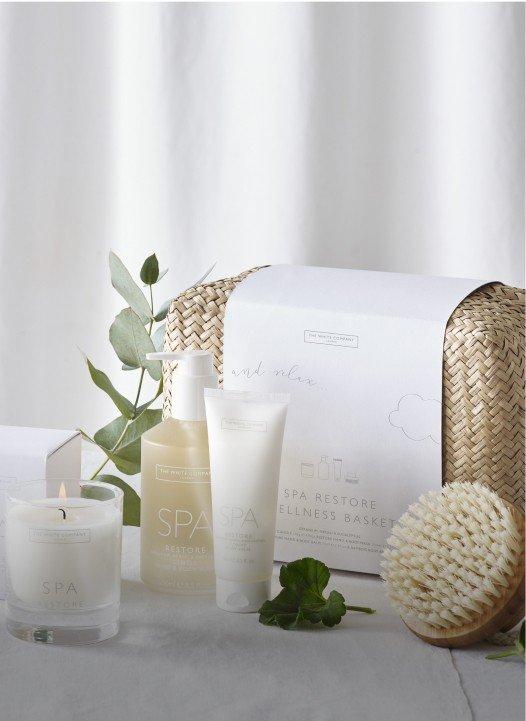 a white basket with a candle, a candle holder, and a candle