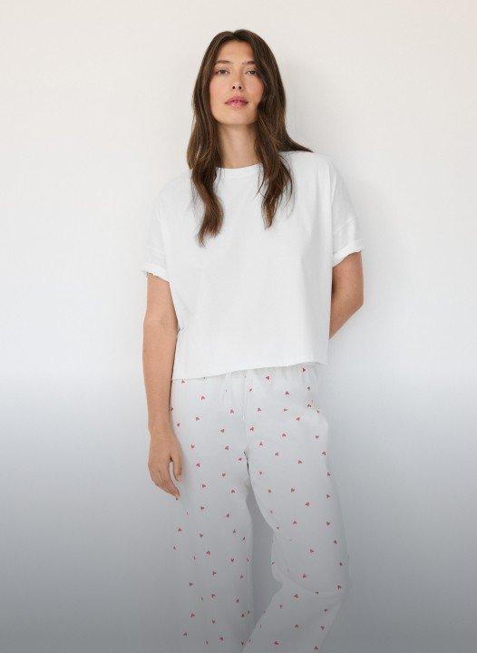 a woman in white shirt and pink polka dot pajamas