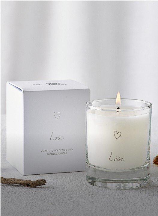 a candle next to a box with a leaf on it