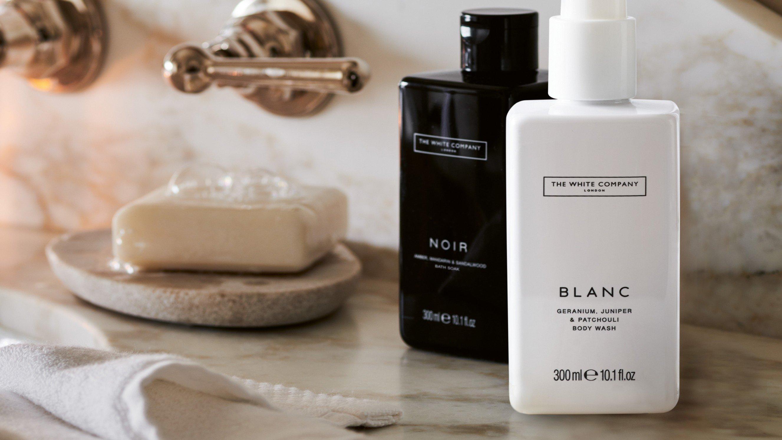 a bathroom sink with soap and toothbrush on marble counter