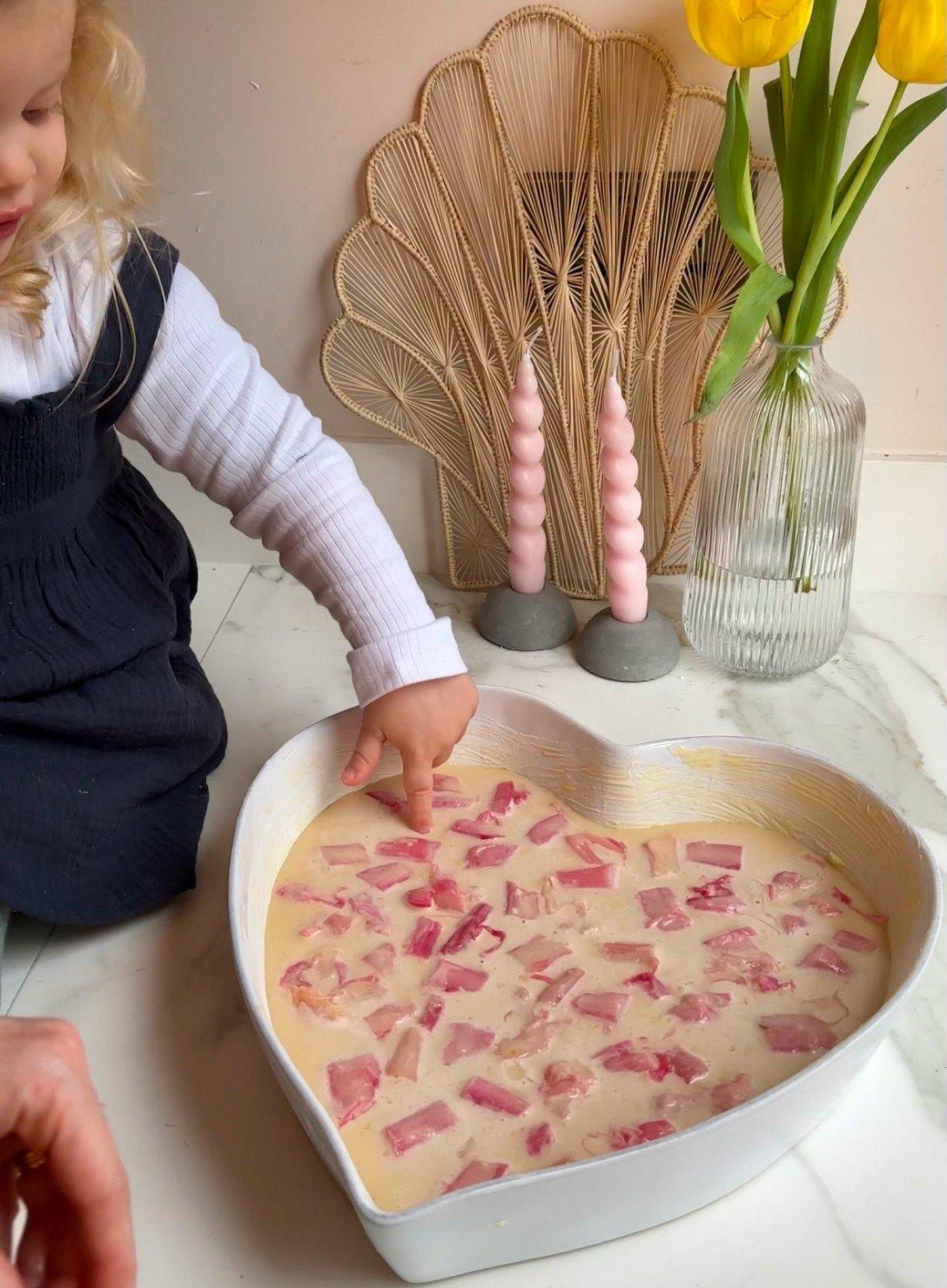 a little girl playing with a heart shaped bowl of food