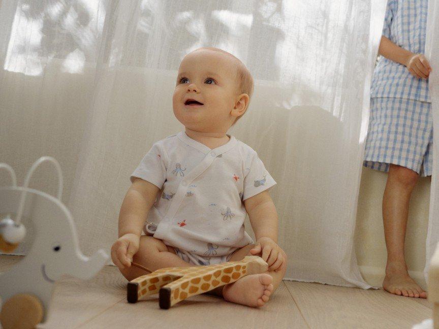 a woman holding a baby in her arms while sitting on a chair