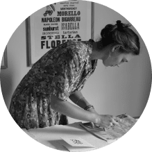 a woman cutting out a piece of paper in a circular shape
