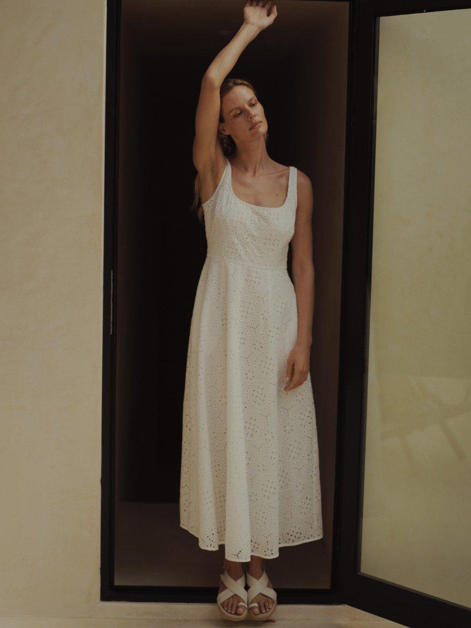 a woman in a white dress standing in a doorway