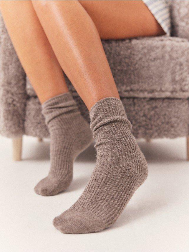 a woman's legs are shown in grey socks