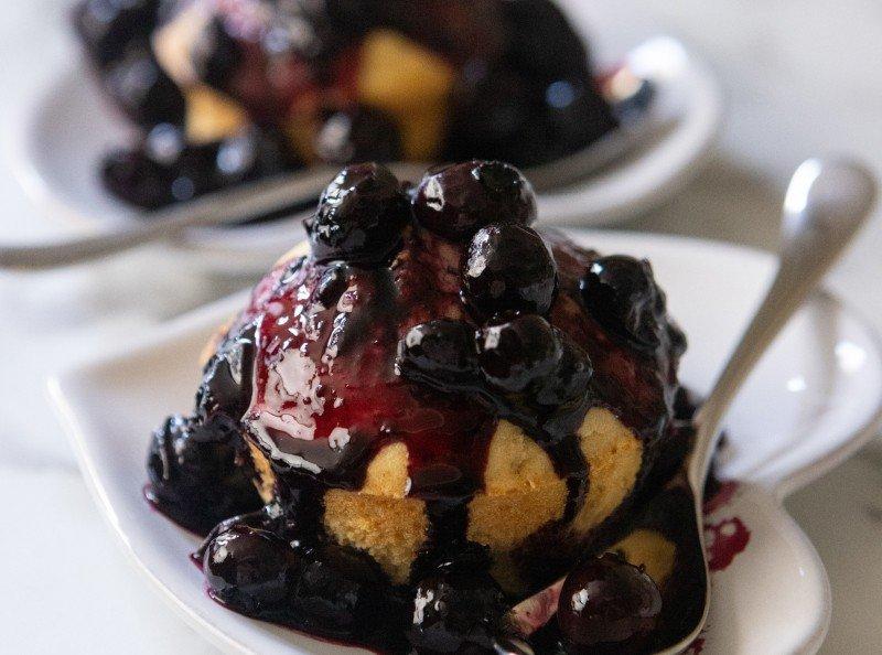 a dessert with blueberries and whipped cream on a plate