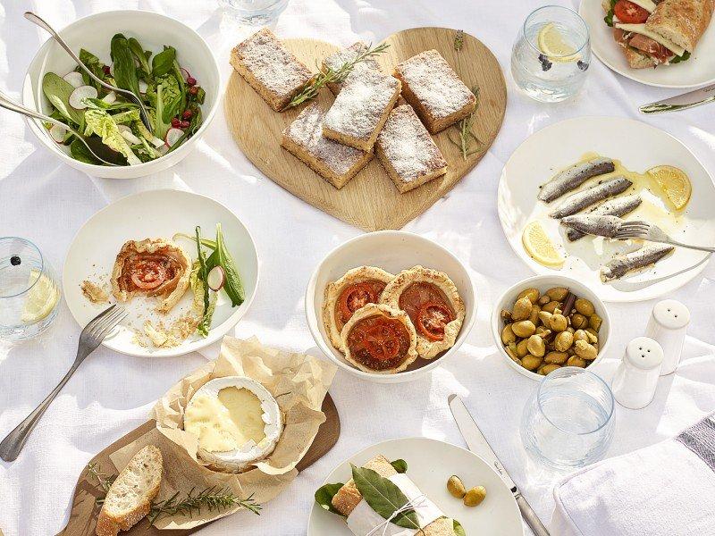 a table topped with plates of food and bowls of salad