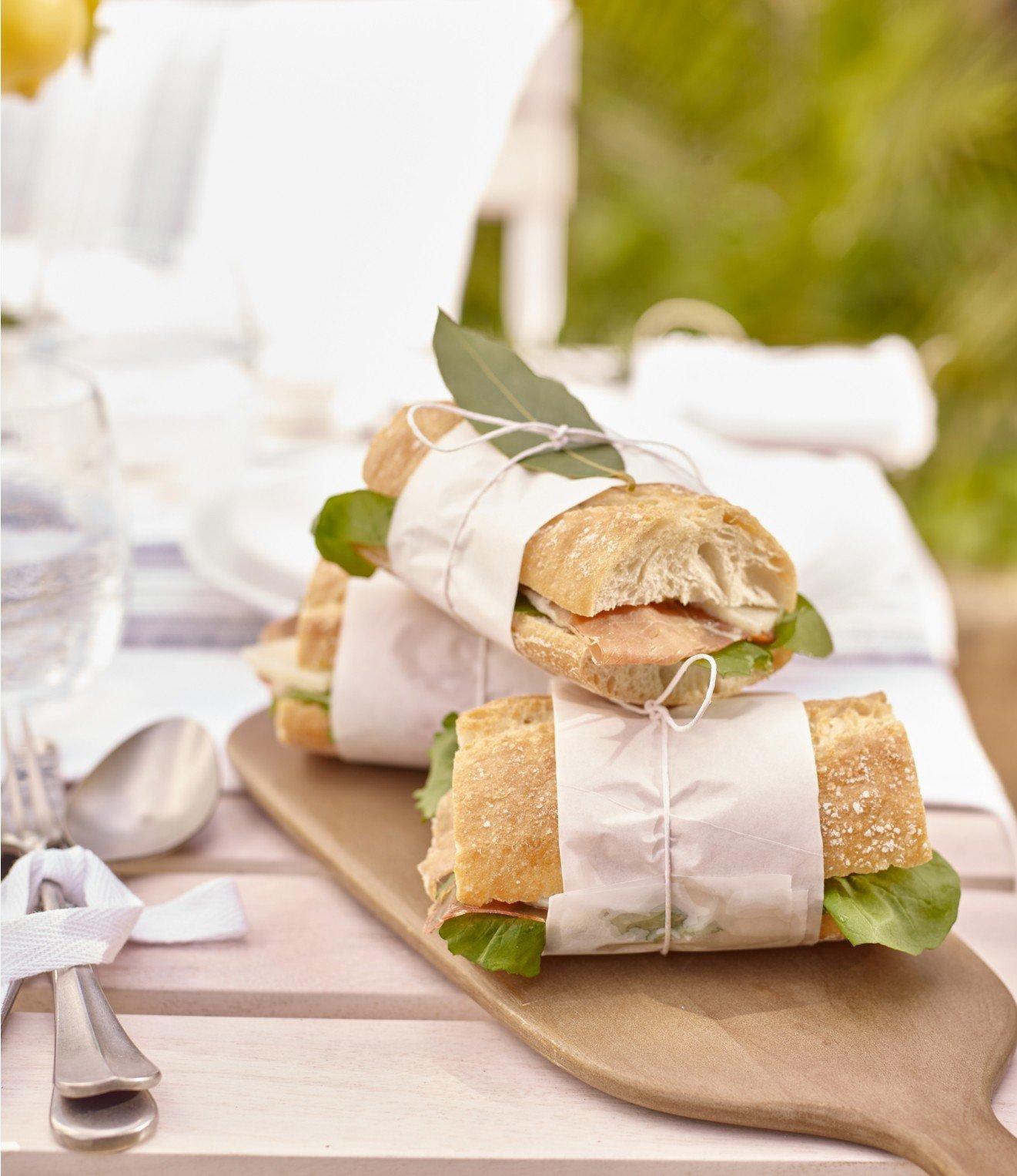 a wooden cutting board with sandwiches on it and a spoon