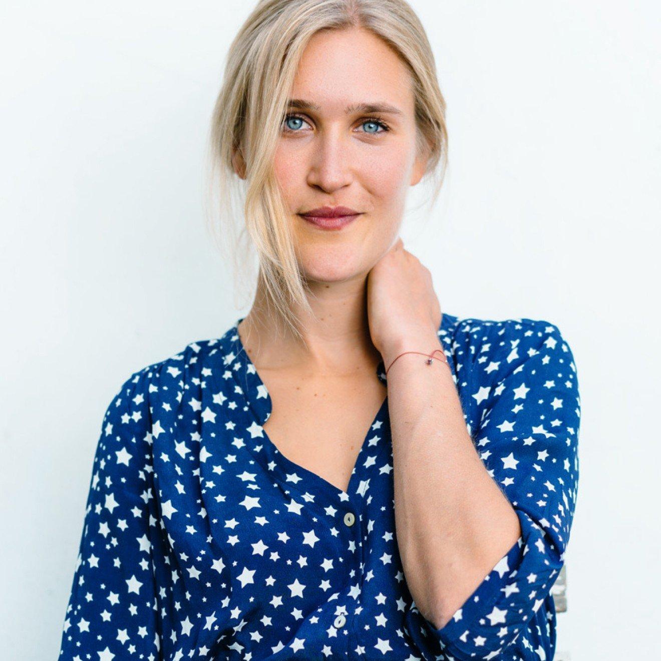 a woman in a blue dress holding a plate of salad