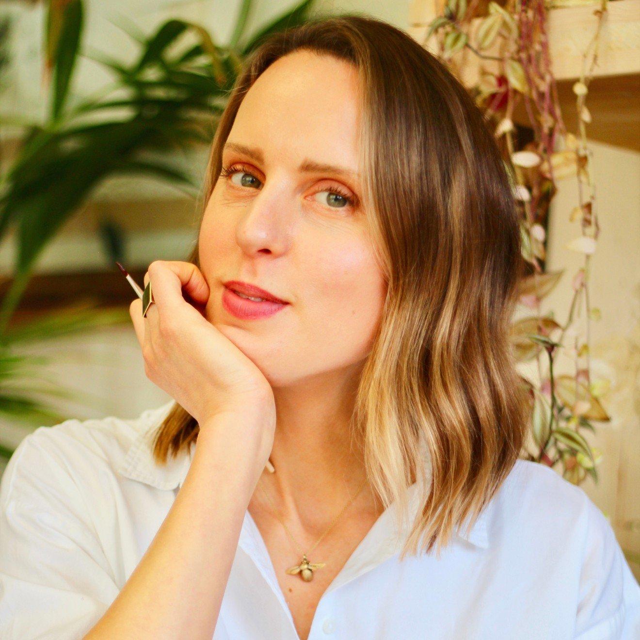 a woman with a white shirt and a hand on her chin