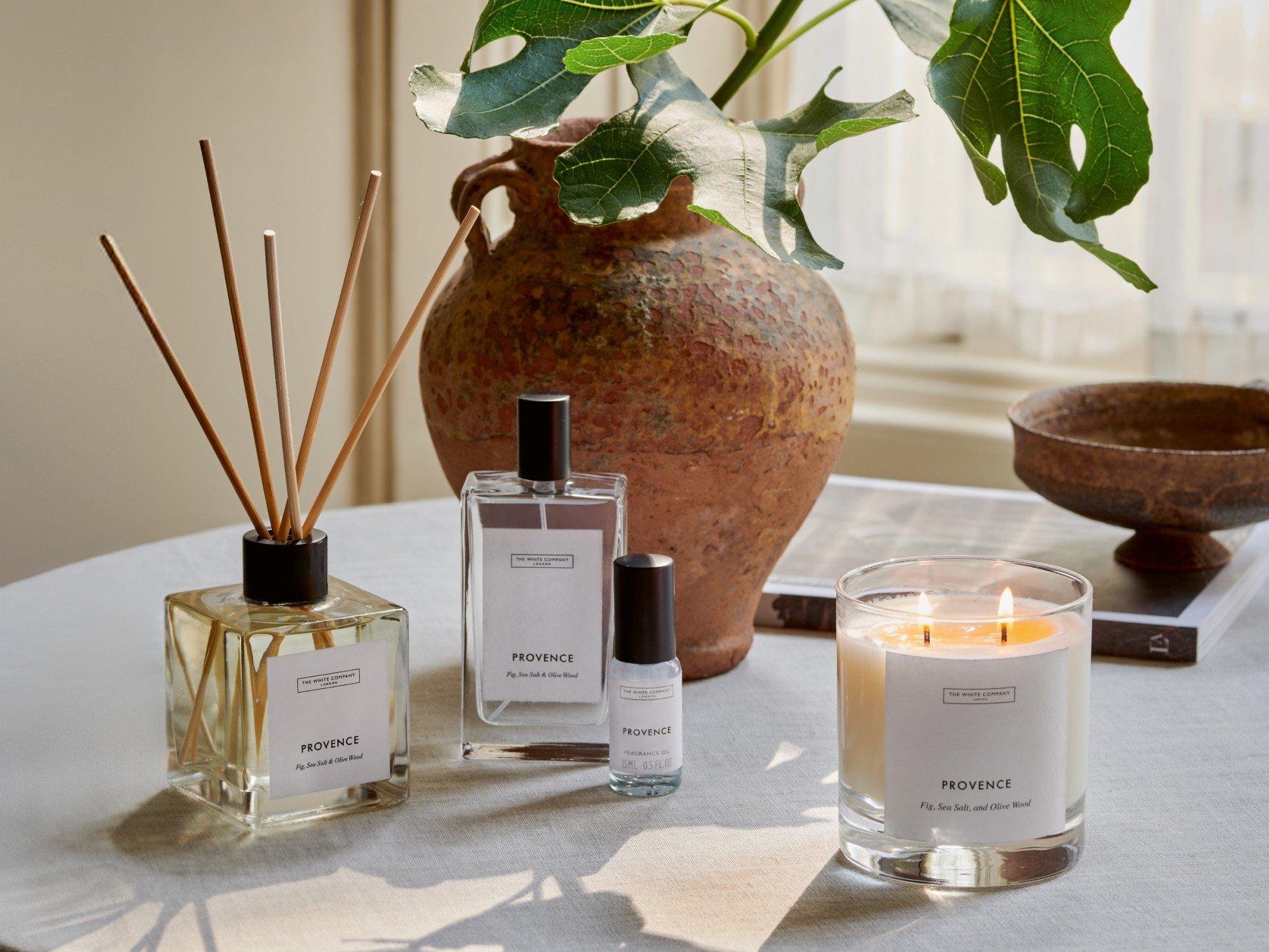 a table with a vase, candles, and a plant on it