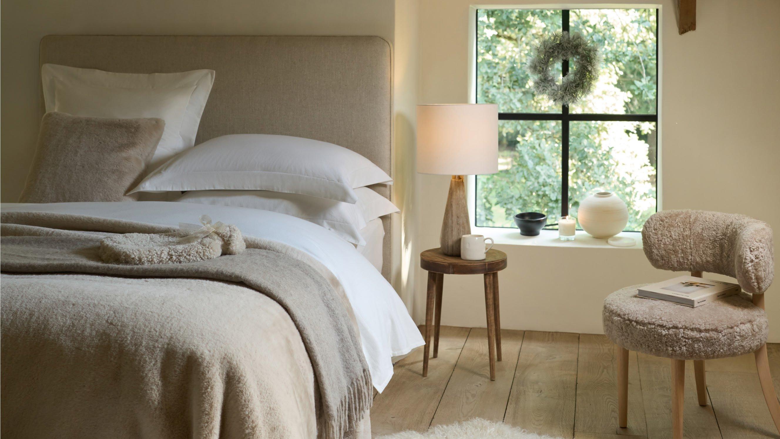 a bedroom with a bed, chair, and a window with a view