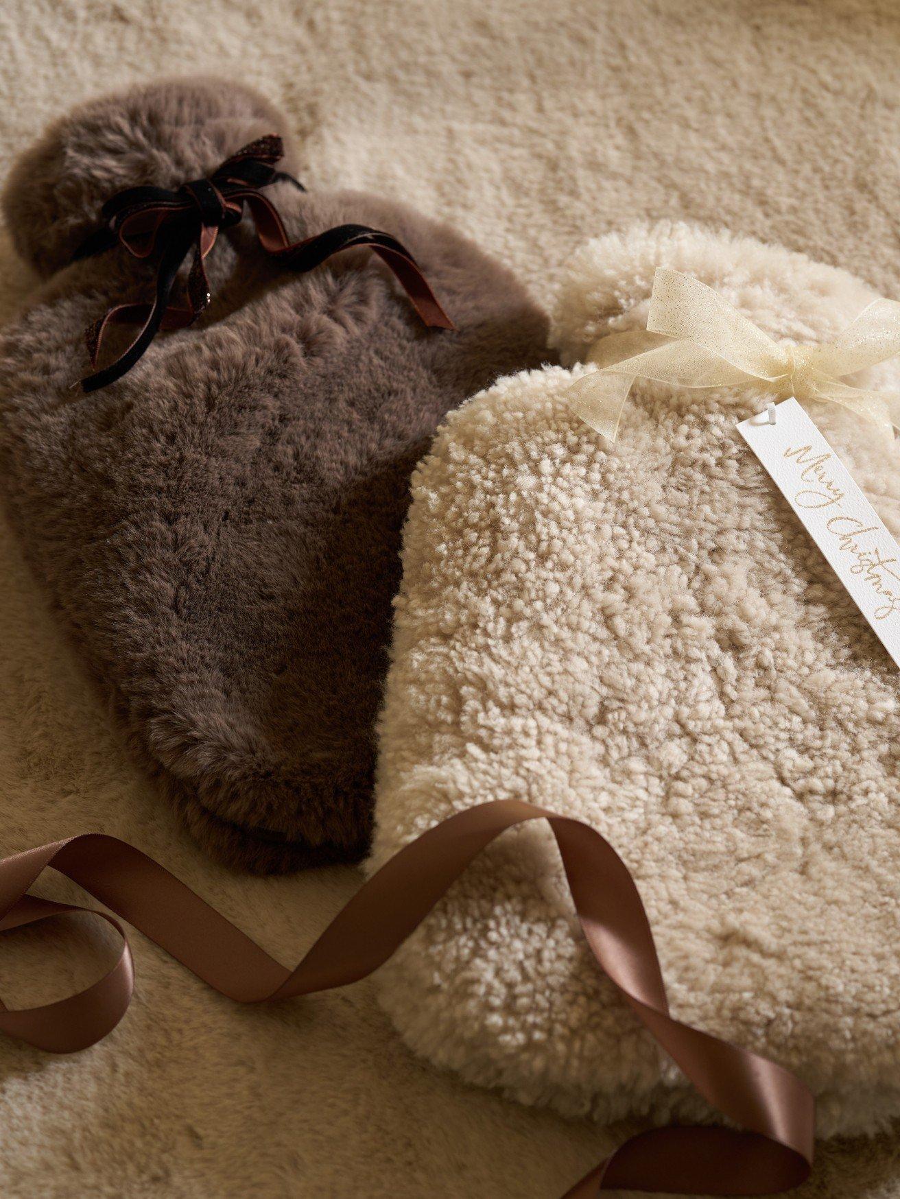 two small hot water bottles are laying on a carpet