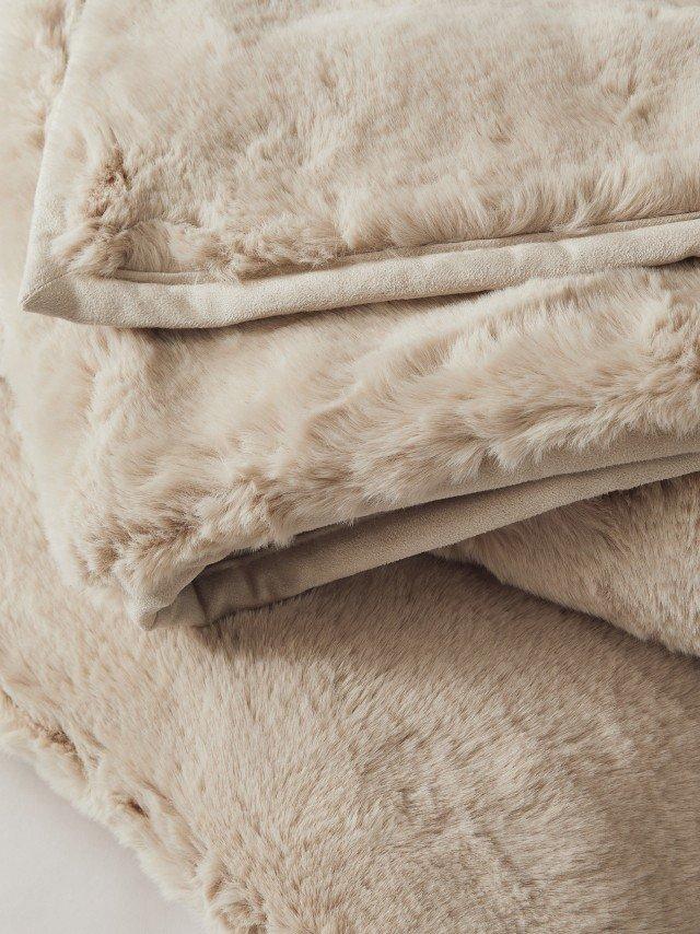 a pile of blankets with fur on them on a white surface
