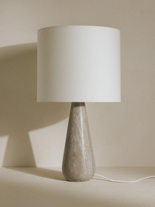 a table lamp with a white shade on a white table