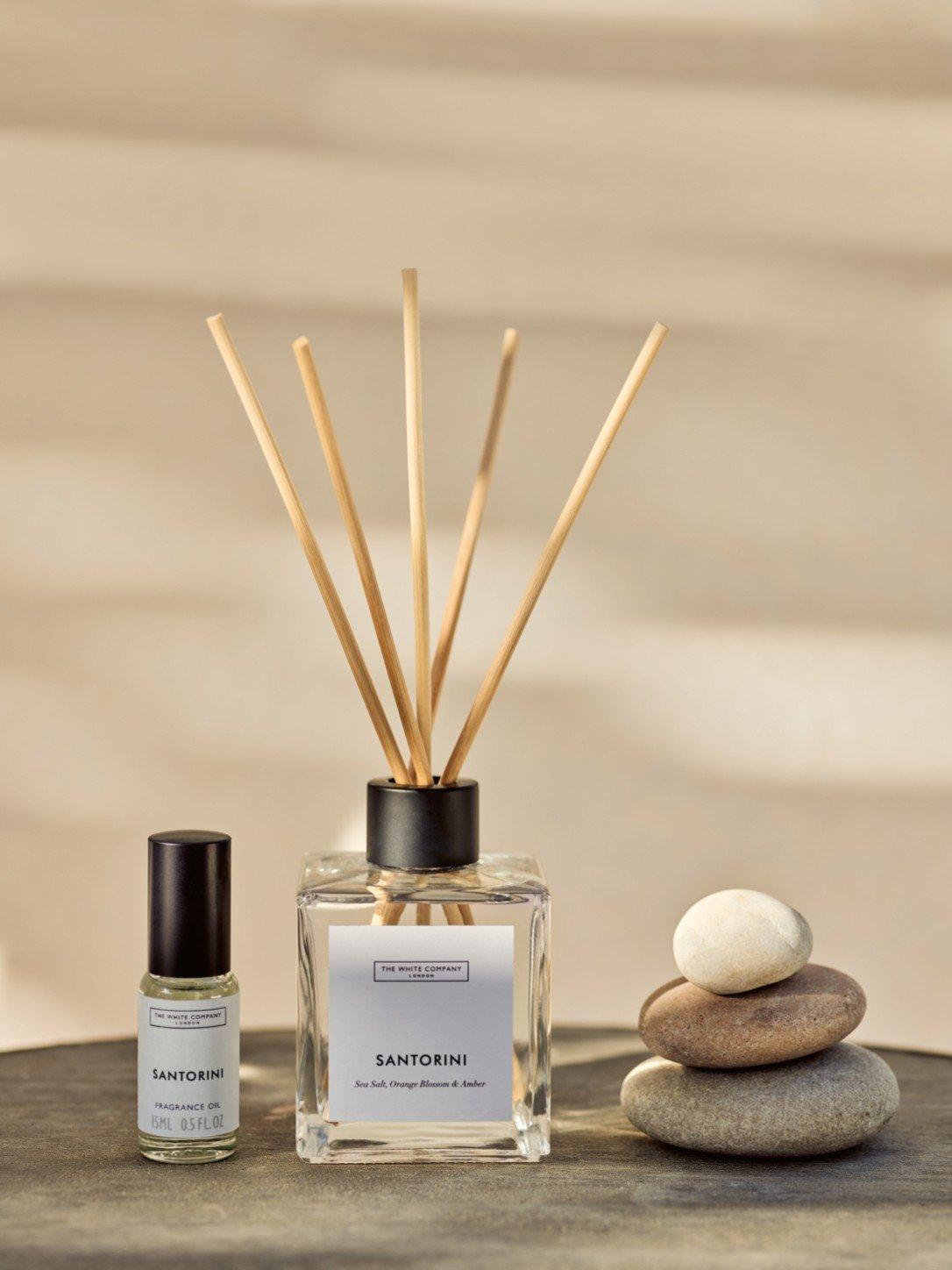 a bottle of essential oil and a reed diffuser on a table