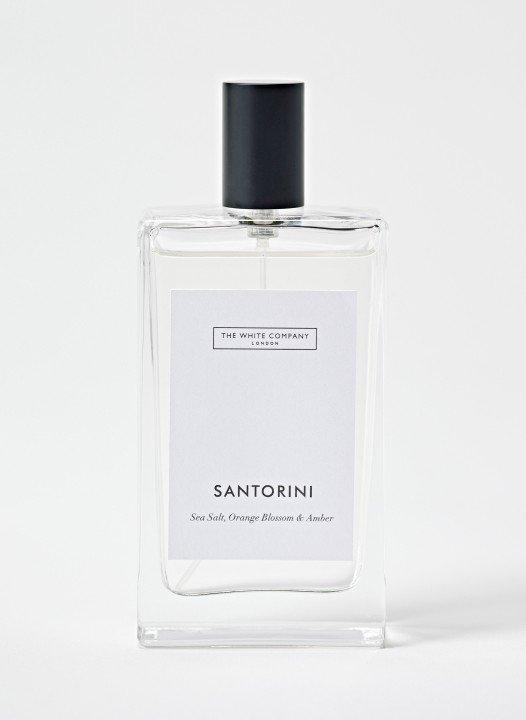 a bottle of santoniini perfume on a white surface