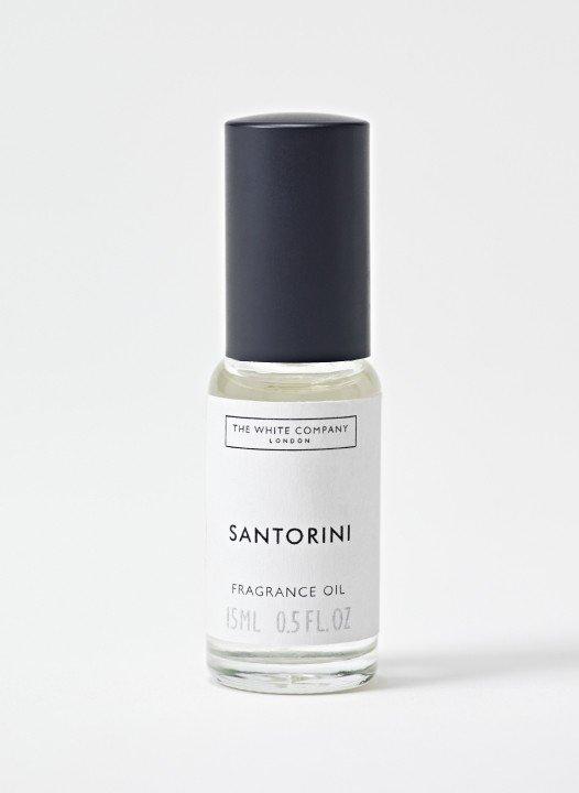 a bottle of santoriin perfume on a white surface