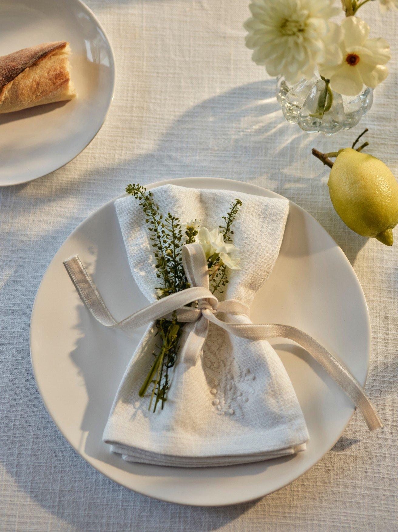 a white plate with a napkin folded in a flower pattern