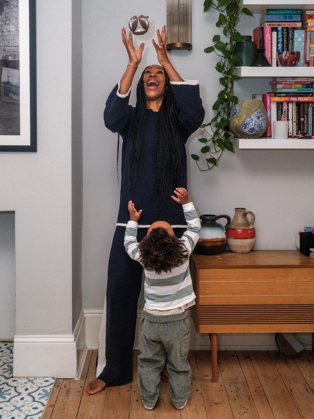 a woman and child standing in a room with a bird