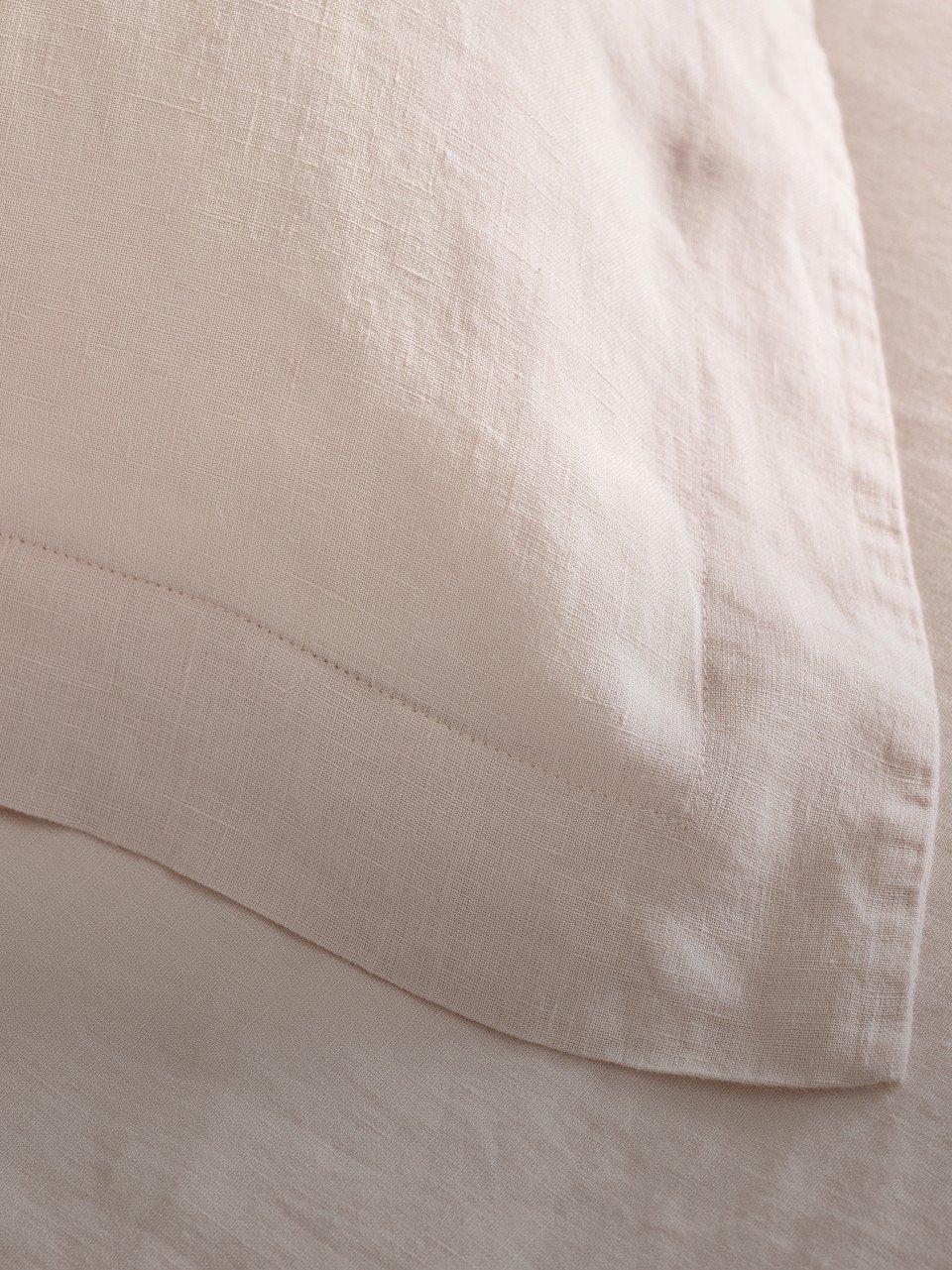 a close up of a white bed with a white pillow