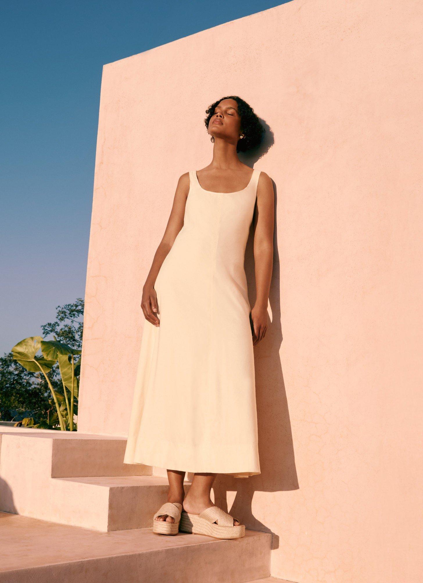 a woman in a white dress standing in a room