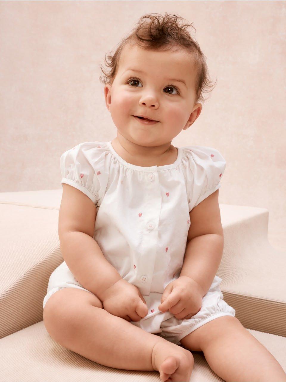 a baby sitting on a step with a smile on her face