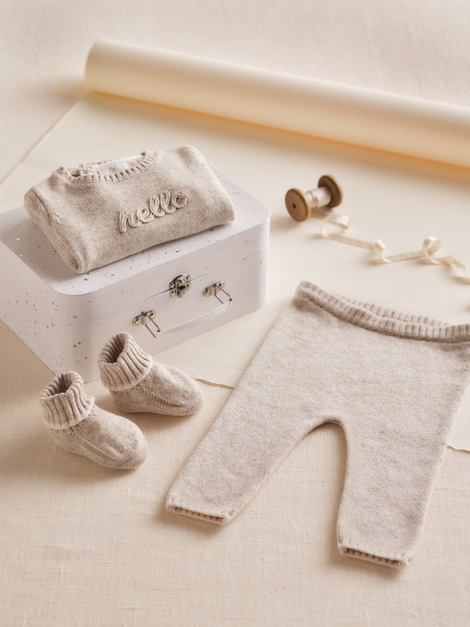 a baby's clothes and accessories are laid out on a table
