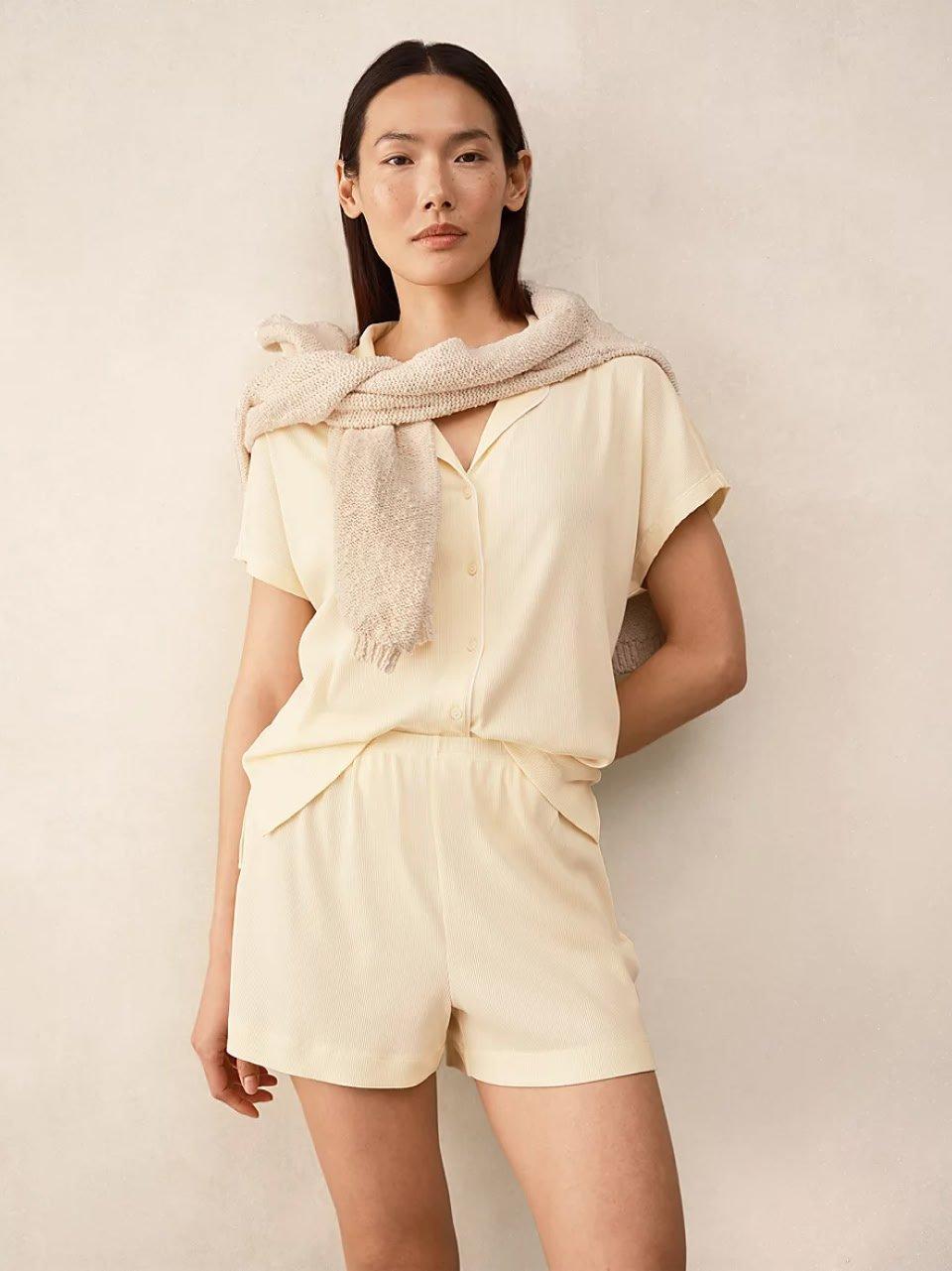 a woman in a white shirt and shorts posing for a picture