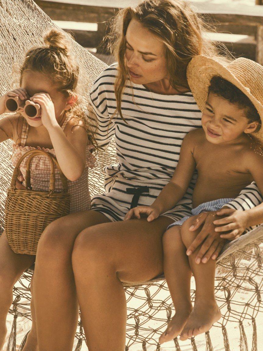 a woman and a child on the beach taking a picture