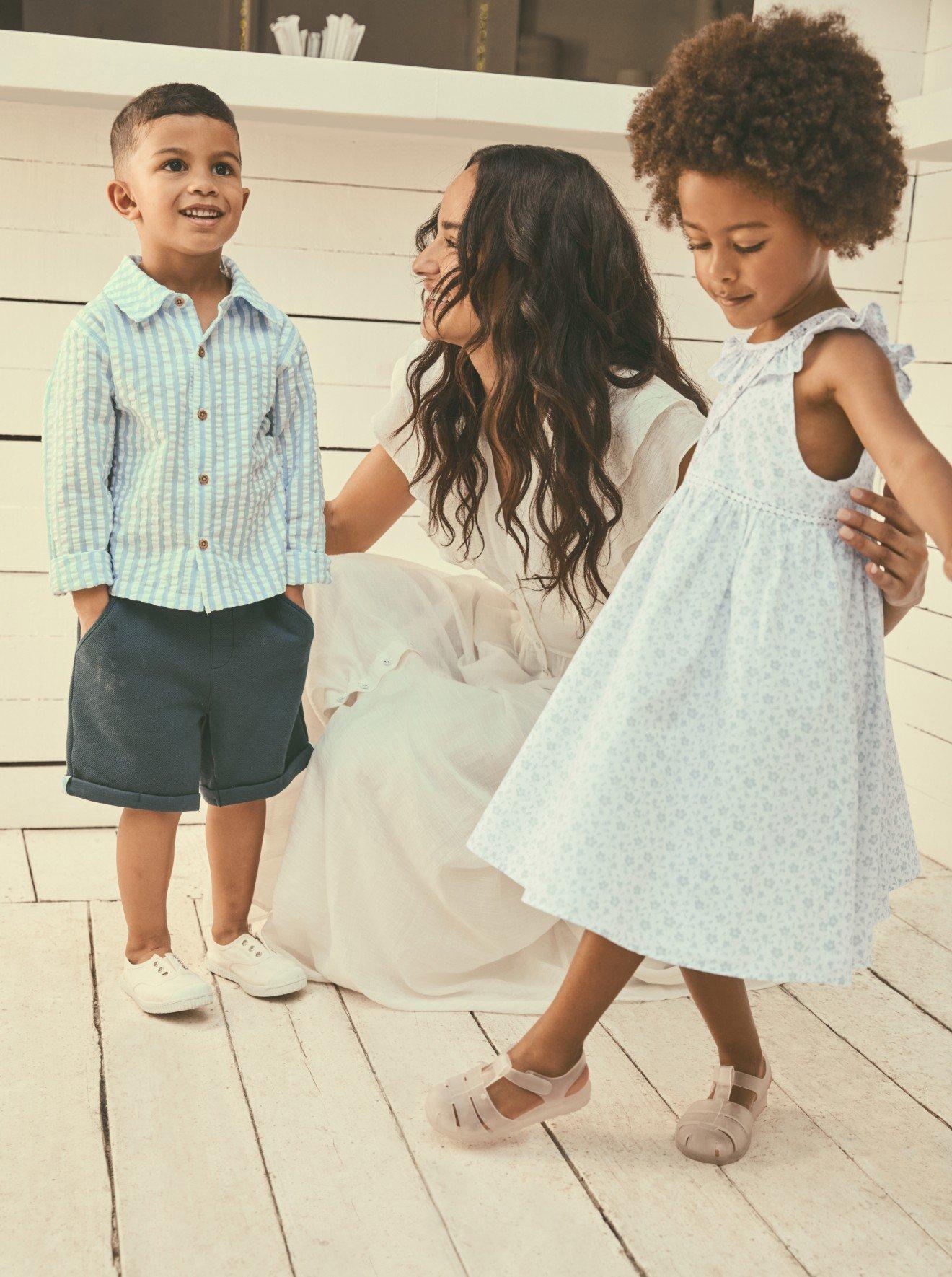 a woman and two children on a wooden floor in a room