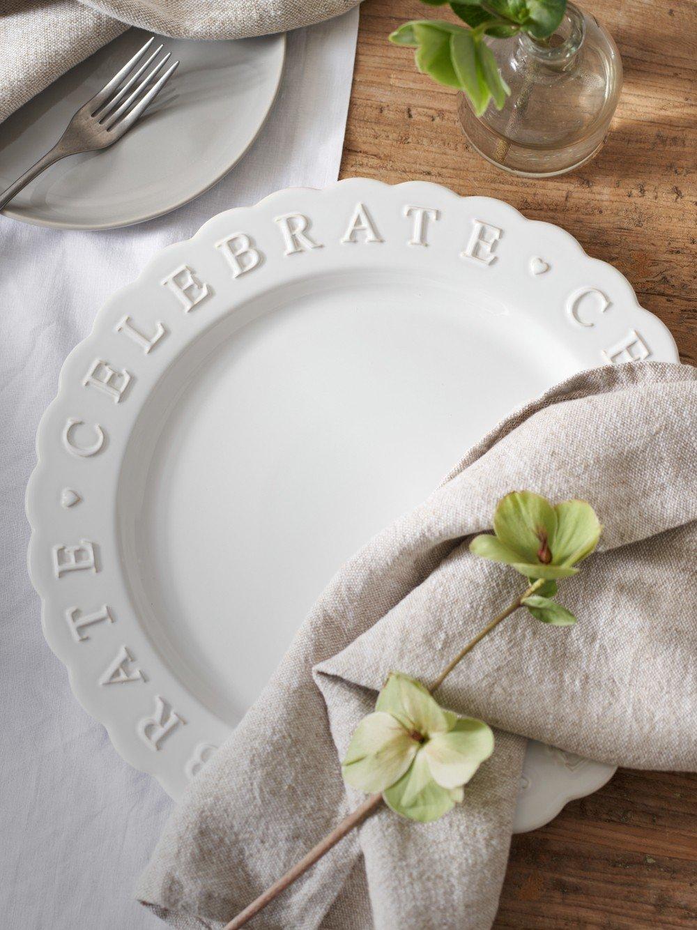 a white plate with a flower on it sitting on a table