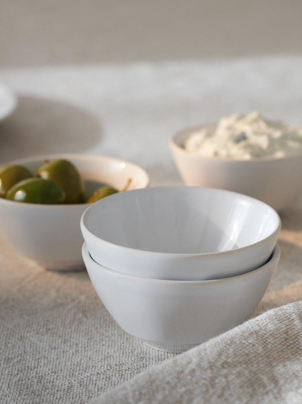 a table with three bowls of food on it and a spoon