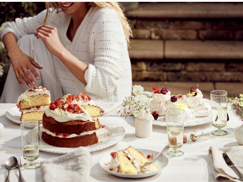 a woman sitting at a table with a cake on it