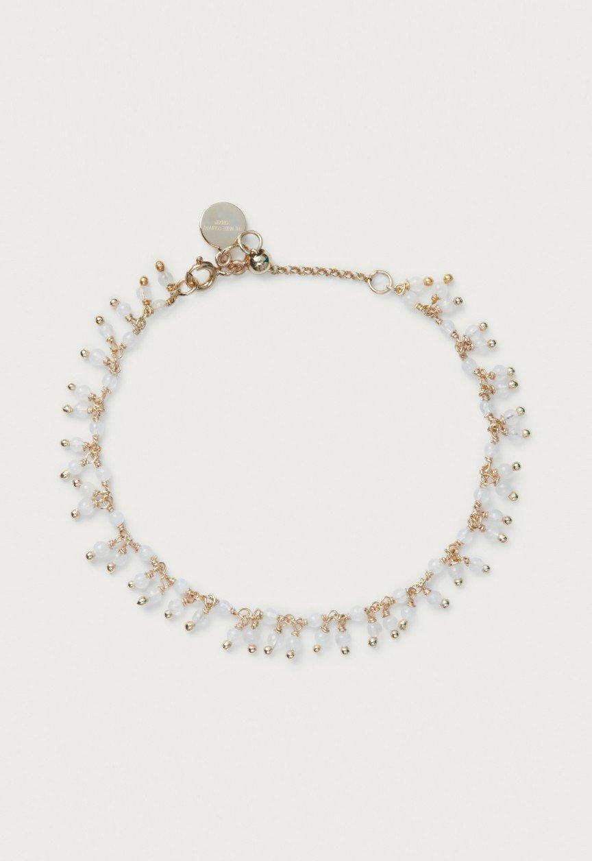 the gold chain bracelet with a white stone and a gold charm