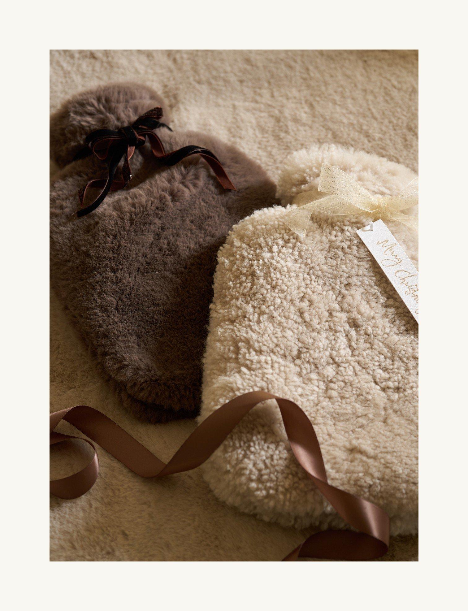 two small hot water bottles are laying on a carpet