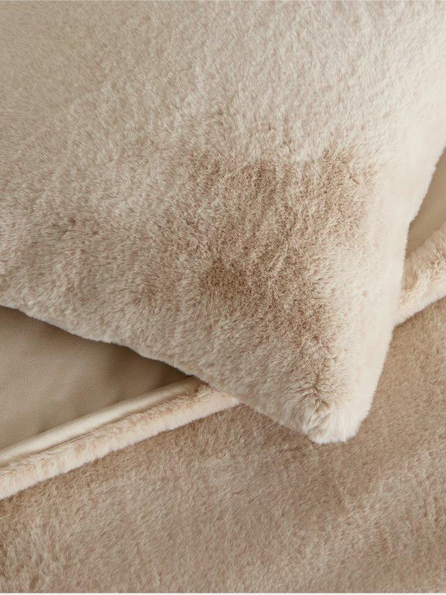 a close up of a pile of pillows on a bed