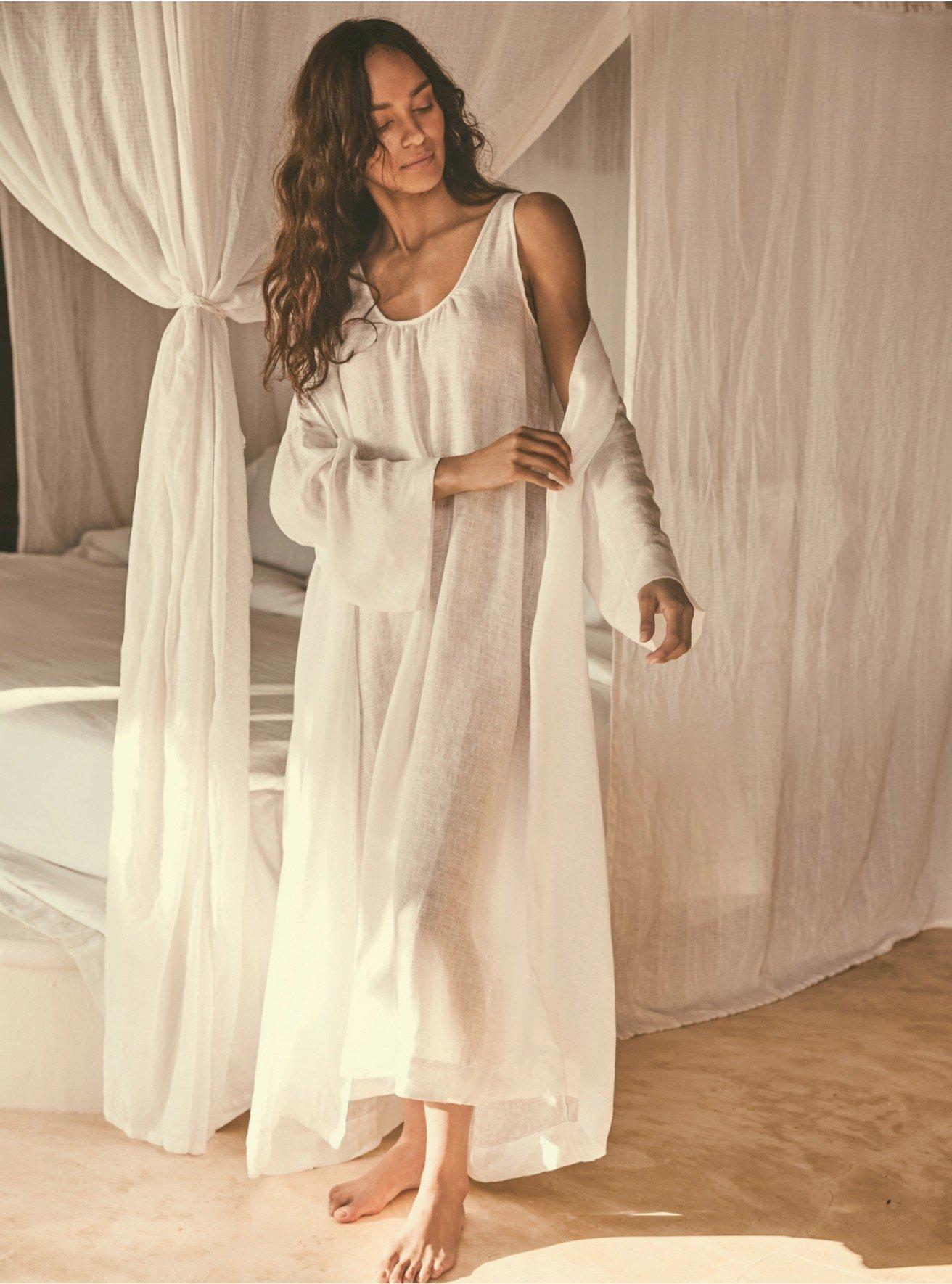 a woman in a white robe standing in a room