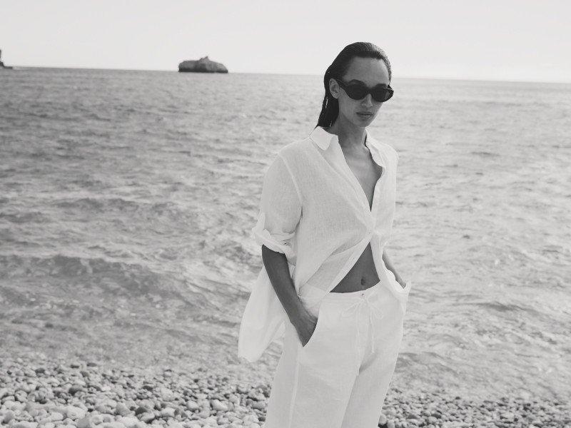 a woman in white standing on the beach