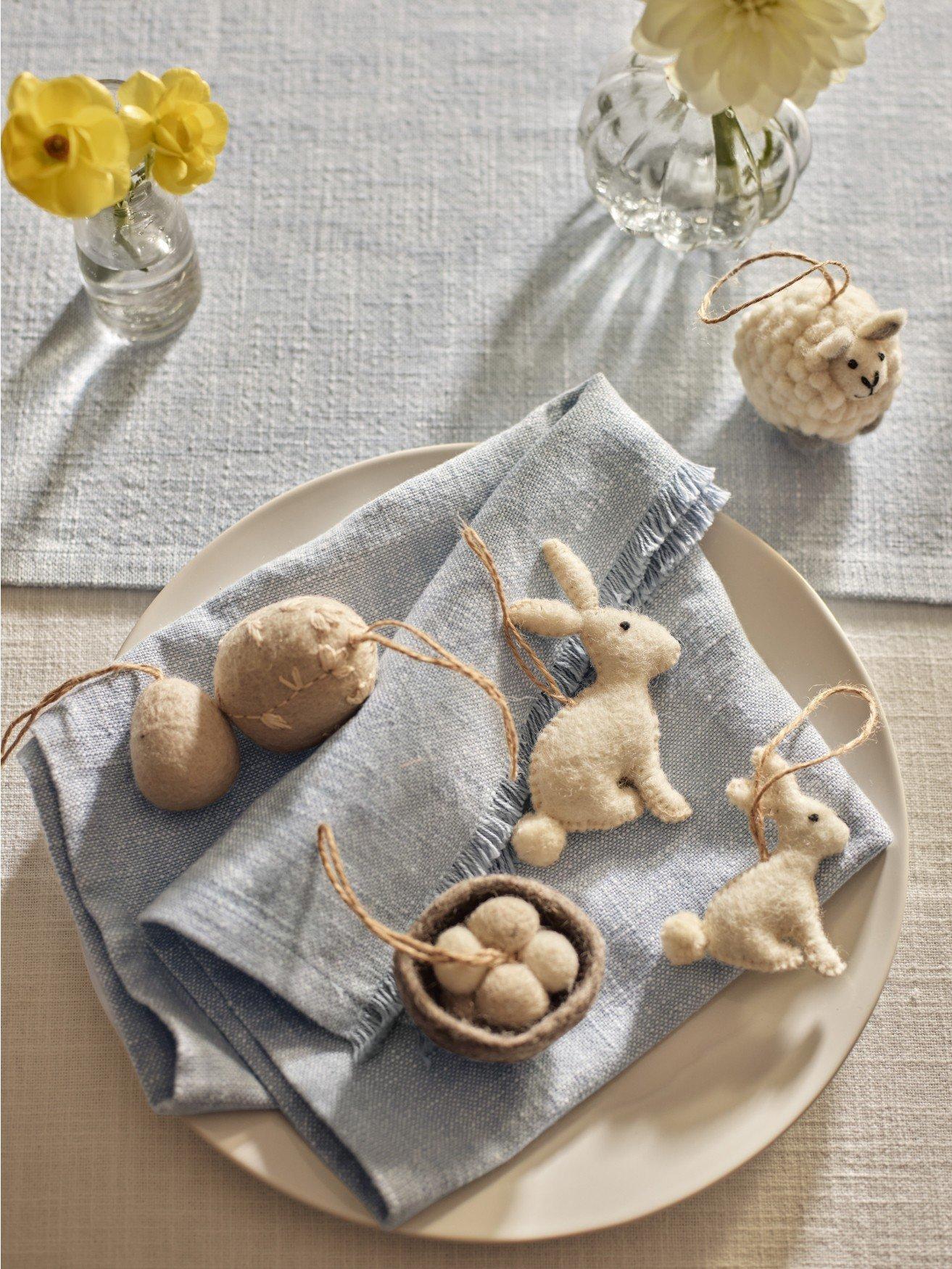 a white plate with a blue napkin and a bunch of stuffed animals