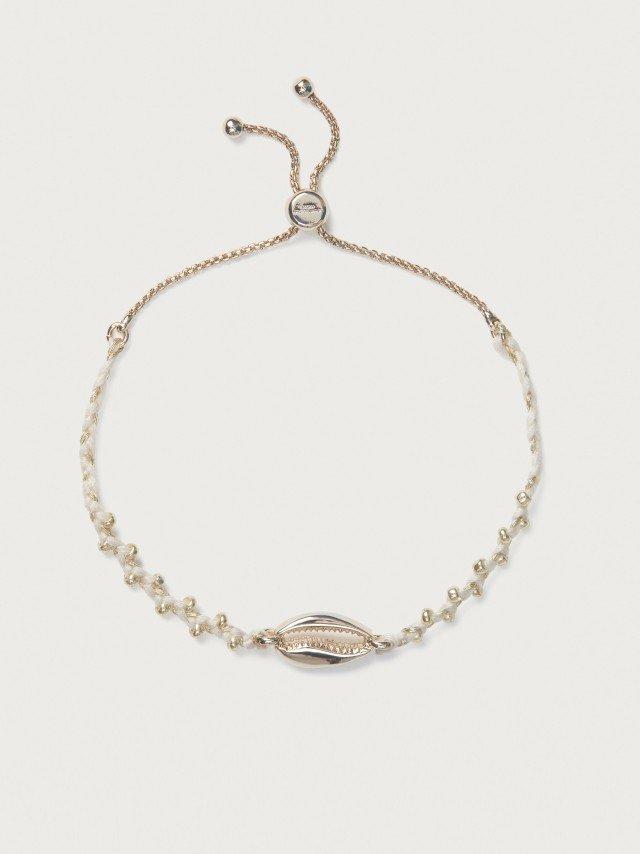 a bracelet with white shells and a gold chain