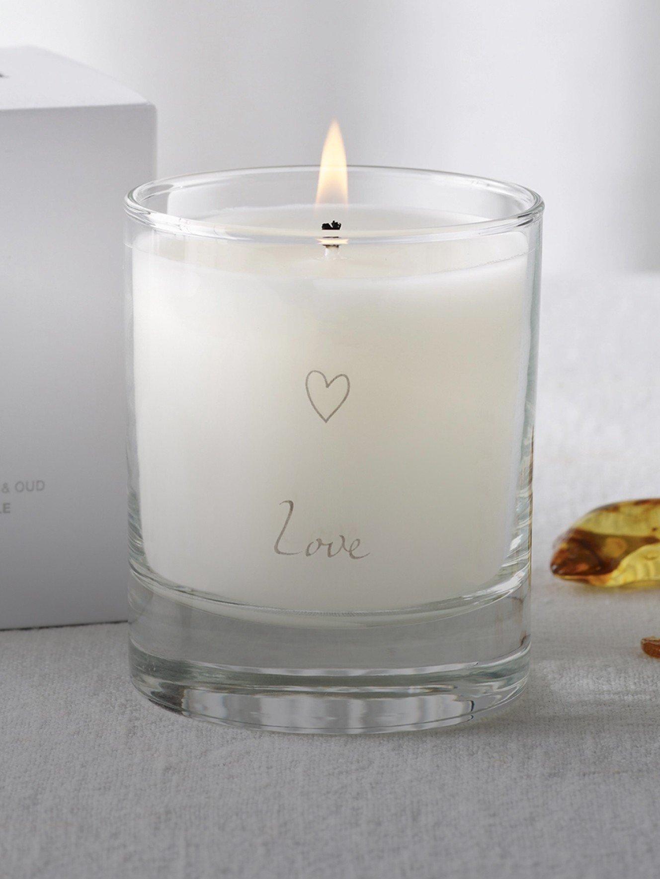 a candle with a love message on it sitting next to a box