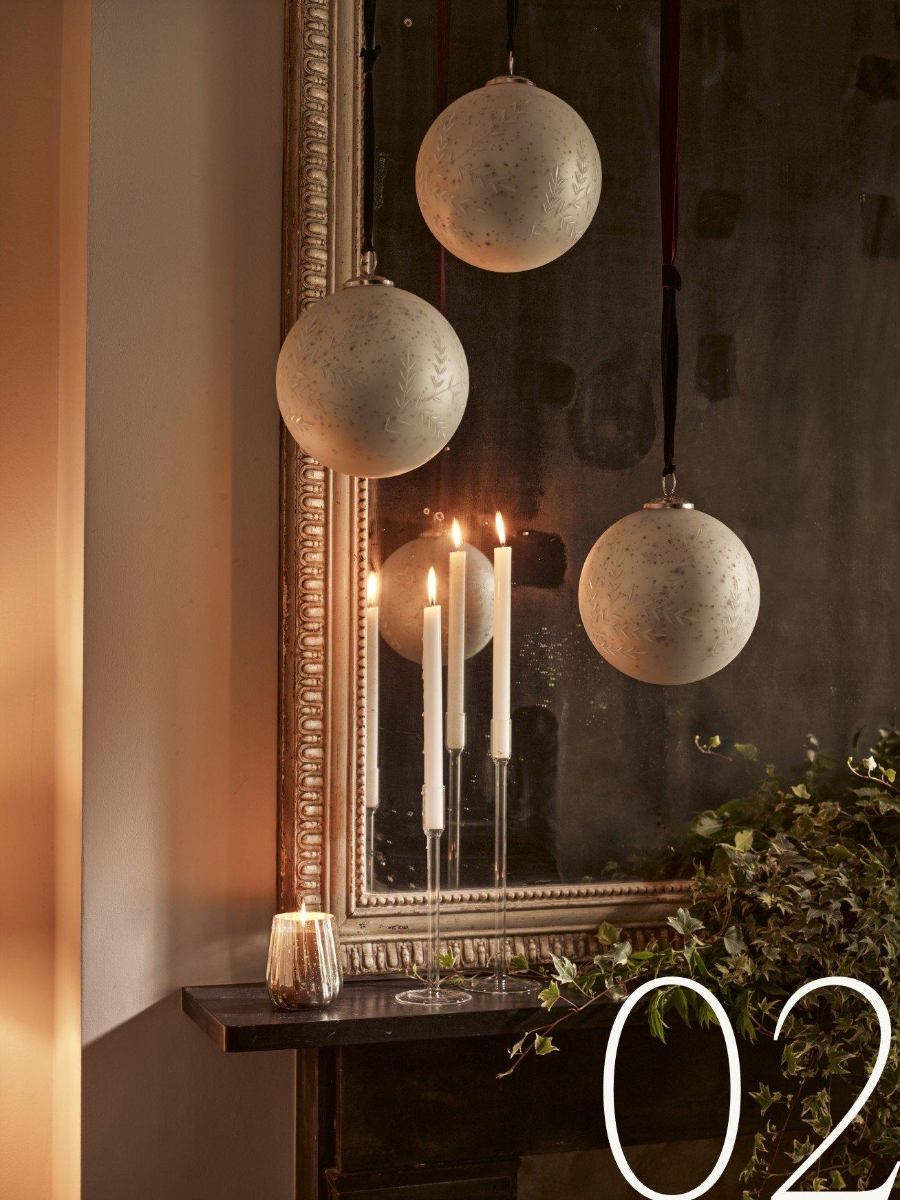 a mirror with candles and ornaments on it and a fireplace