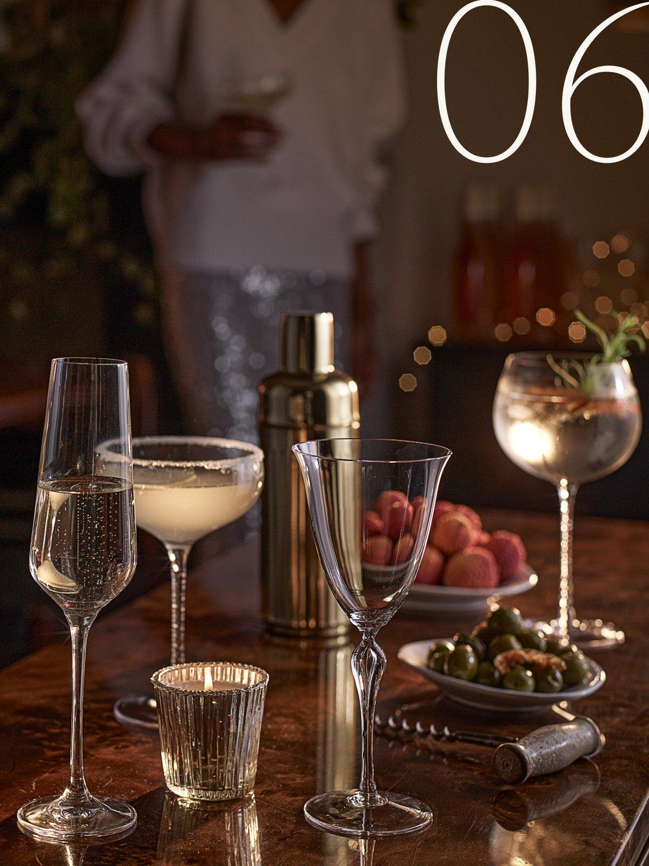 a table with a bunch of glasses and a bottle of wine