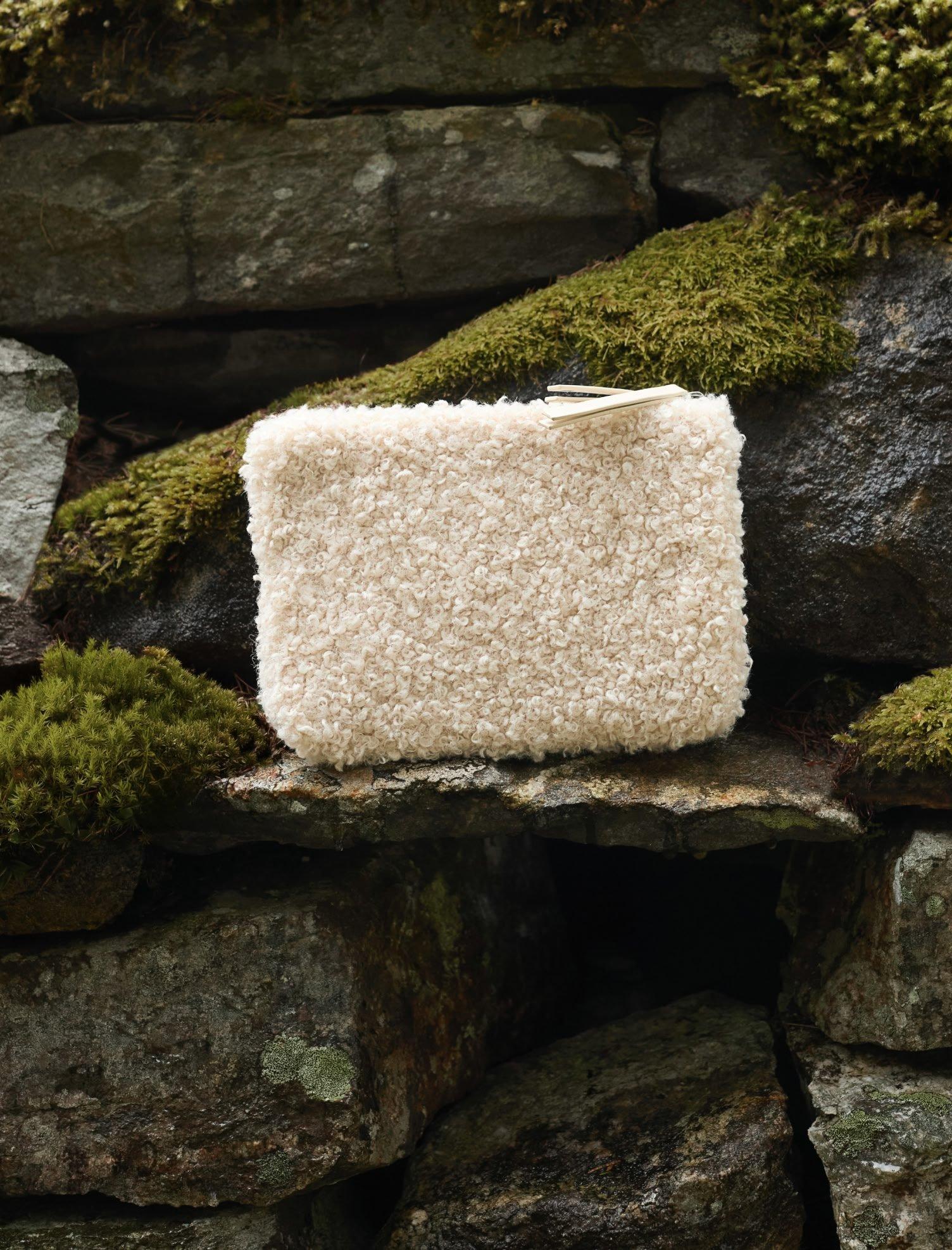 a small white bag sitting on top of a rock covered in moss