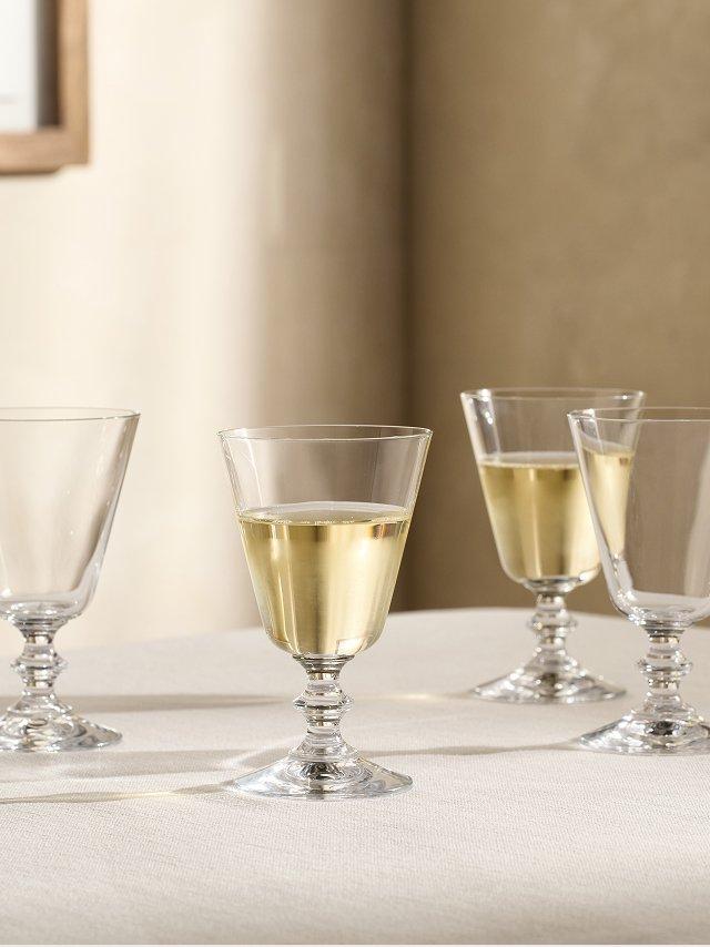 a group of wine glasses on a table with a white cloth