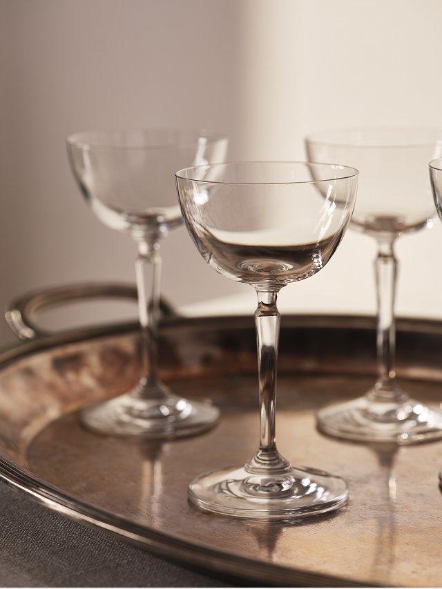 a tray with four empty wine glasses on it sitting on a table